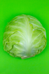 Obraz premium Green cabbage on the green background. Close up. Macro photo. Minimalism, original beautiful food photo.