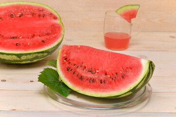 a large piece of watermelon and a glass of juice in the background