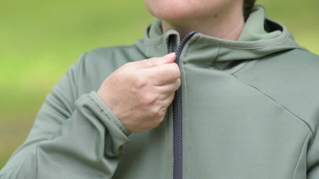 Female jogger zipping her jacket