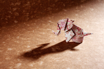 Origami elephants isolated on craft paper background.