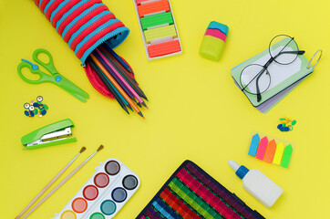 Back to school. School supplies: scissors, stationery buttons, stapler, brushes, paints, notebook, glue, grater, glasses,Rubik's cube, notebook,pencil case, bookmarks, pencils,plasticine.Bright colors