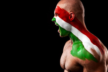 Fototapeta premium Hungary fan. Soccer or football athlete with flag bodyart on face. Sport concept with copyspace.