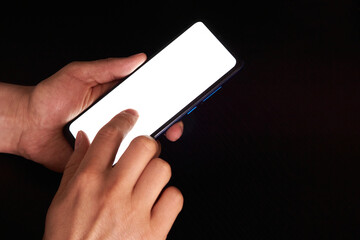 A person using his smartphone with a white screen, ready to place any design on a black background