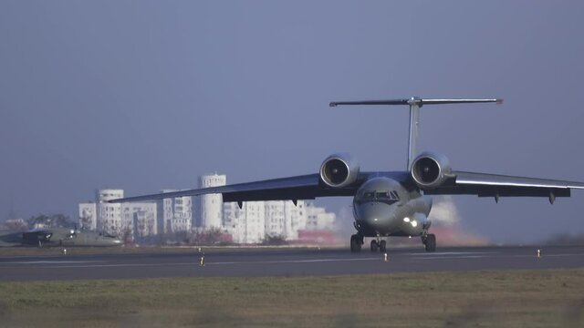 Military airplane is taxiing on the runway after landing
