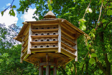 Big hexagonal bird house shelter wood nest in a forest