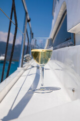 A glass of white wine on the deck of a yacht during a summer seaside holiday on a sunny day.
