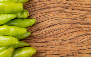 Green cheiro (smell,scent) peppers over wooden table with copy space