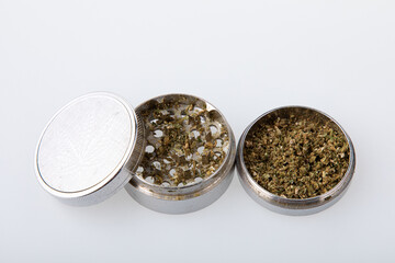 Metallic hemp grinder with cannabis in it.