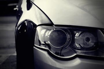 Close up view of a car headlight. Rare car with 2 colors. Creative black and white photo.