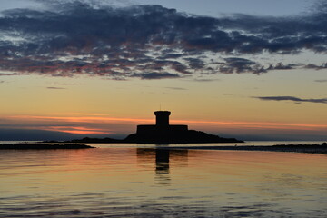 St Ouen's Bay, Jersey, U.K. 19th century military Rocco tower at sunset in Spring.