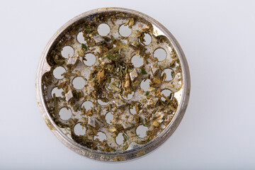 Metallic hemp grinder with cannabis in it.