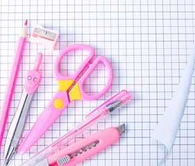 Pink stationery is laid out on a checkered sheet. Top view
