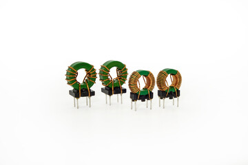 Different kinds of ring core inductors arranged in two lines on white background