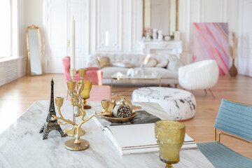 very light baroque style luxury interior of big sitting room. White walls decorated with awesome stucco. Royal style apartment with chic furniture with gold elements