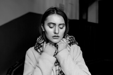 Black and white indoor portrait of a sad lovely woman