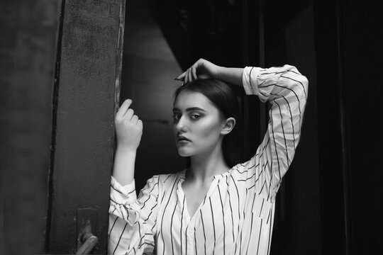 Black and white indoor portrait of a sad fabulous young woman wears striped white shirt