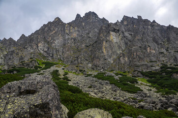 Landscape with high stone sharp rocky peaks under cloudy sky in National Park High Tatras Mountains, Slovakia. Tourist destination for hiking and tourism