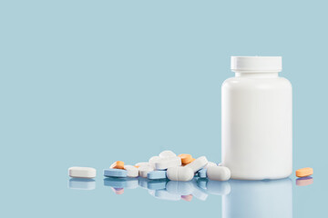 Medical background of many white capsule tablets or pills on blue table. Close up. Healthcare pharmacy and medicine concept with copy space Painkillers or prescription drugs consumption. Mockup jar