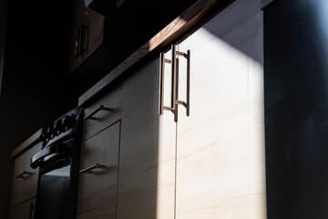 bathroom cabinets handles in contrast of natural light and shadows