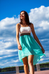 Happy beautiful brunette woman in a turquoise dress