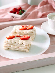 milfey cake with cream and strawberries and cup of coffee.