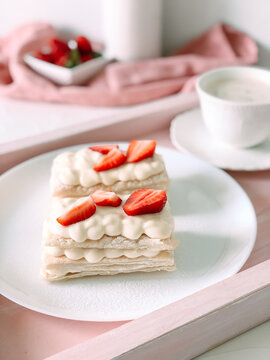 milfey cake with cream and strawberries and cup of coffee.