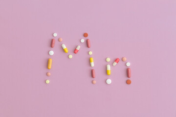 Manganese symbol made from pills on purple background. Top view with copy space. Flat lay.