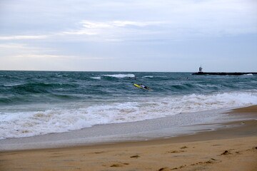 Surfer on the beach with waves