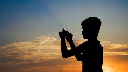 Young phone photographer capturing the sunset