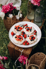 Obraz na płótnie Canvas Pavlova dessert with whipped cream, strawberries and blueberries. portions of Pavlova dessert with berries on a plate top view. summer dessert for outdoor picnic parties.