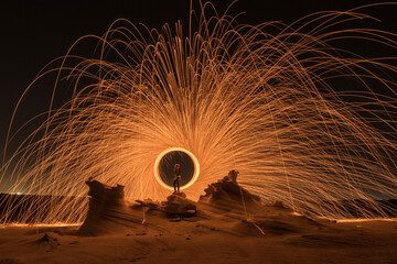 Steel wool photography at the desert rock structure at night time with fire splash all over. Slow...
