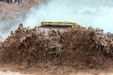 Sportsman on buggy drives splashing in dirt and water at mud racing. ATV and SSV motobiking is popular extreme sport and outdoor activity.