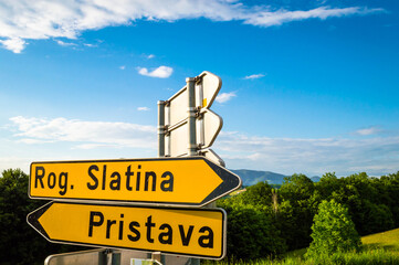 A close up of a sign. Nameplate of old city Rogaska Slatina,Slovenia, South Styria. Summer view. View over valley and surrounding hills.