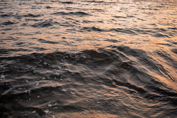 picture of the surface water in the sunset time. The texture of the river water at sunset.