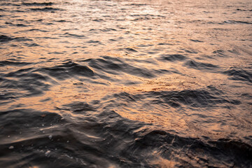 picture of the surface water in the sunset time. The texture of the river water at sunset.