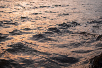 picture of the surface water in the sunset time. The texture of the river water at sunset.