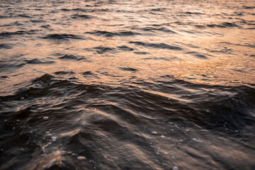 picture of the surface water in the sunset time. The texture of the river water at sunset.