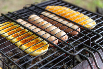 sausages and bread grilled on coals