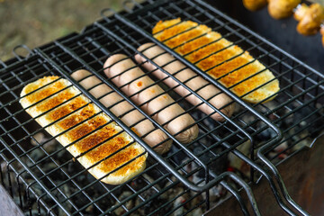 sausages and bread grilled on coals