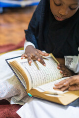 Fototapeta na wymiar A child pointing at texts in the Quran 