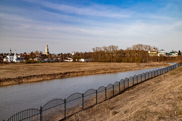 Fototapeta na wymiar The bank of the Kamenka River in Suzdal view from the territory of the Kremlin. A soulful Russian landscape.