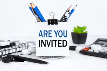 You're Invited! text on white paper near pencil holder