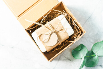 Soap in Craft Gift box or present box with bow on white background with mockup label tag. Copy space for text and design. Package, zero waste, plastic free, eco friendly natural organic concept.