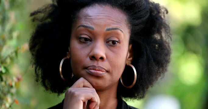 Thoughtful African woman thinking outside, undecided uncertain emotion