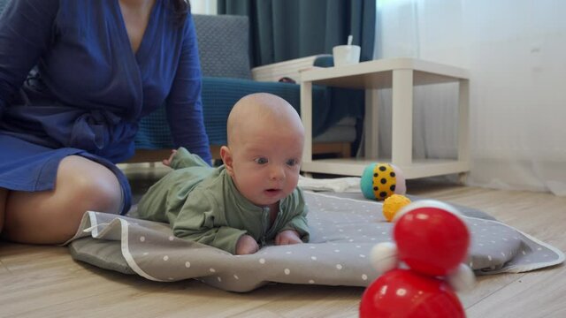 Infant exercise baby lifting head lying on stomach on activity play mat. High quality 4k footage