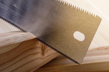 Hand saw and wood planks. Saw with a Japanese tooth. Maple wood.