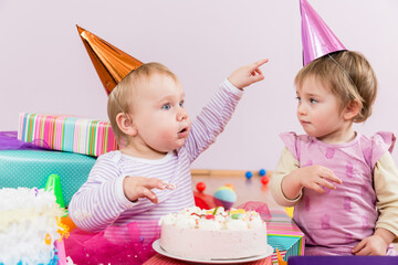 Two toddlers with birthday cake