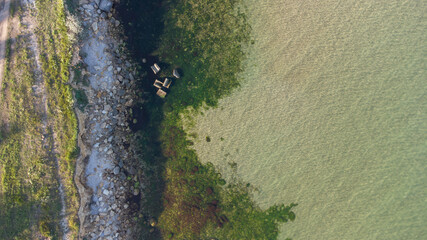 Aerial view of the stony seashore. Transparent water and stones in the water.