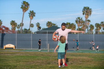 Boy child listen to man trainer explaining basketball rules on sports ground, sport training