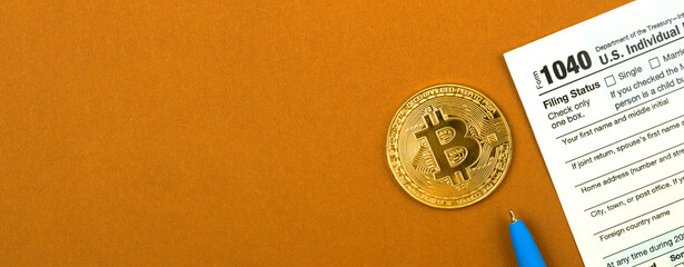 Business office desk with US Individual Income Tax Return form and physical bitcoin coin, top view, banner with copy space